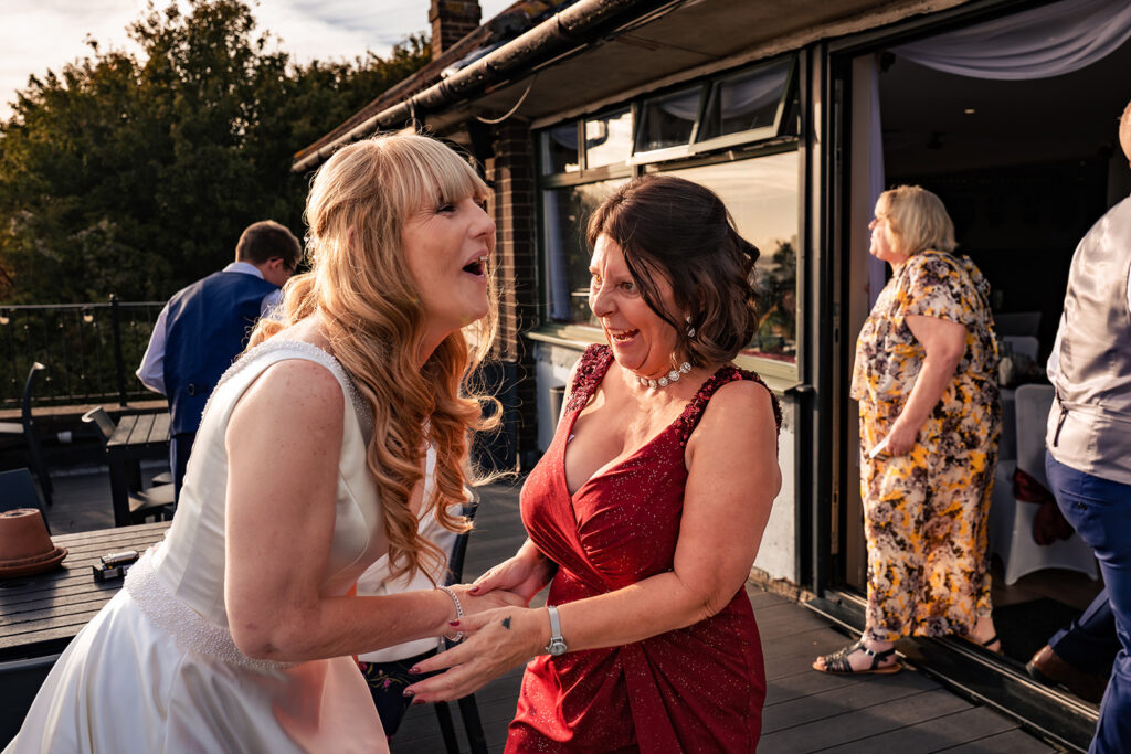 Bride laughing with a guest on the terrace at The Churchillian, Portsdown Hill, Portsmouth