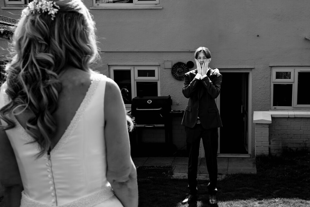 Bride's son seeing his mum in her wedding dress for the first time, black and white, on the morning of a Portsmouth wedding