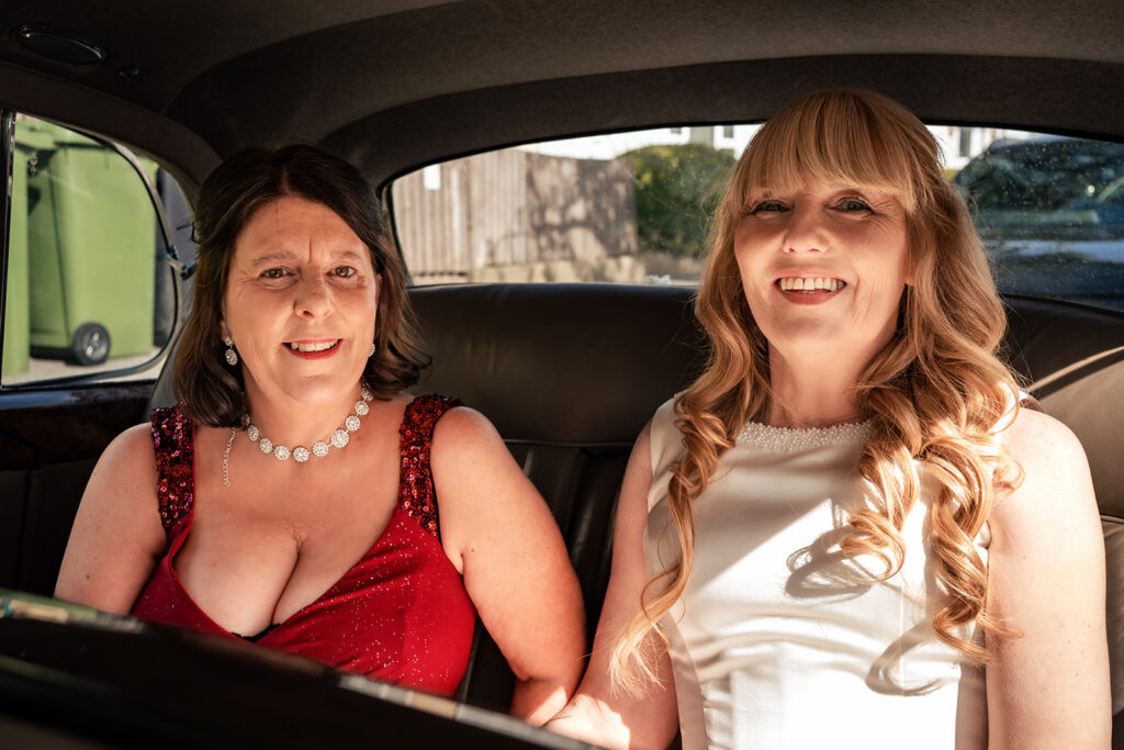 Bride and bridesmaid in the vintage wedding car on the way to Portsmouth Register Office
