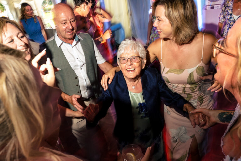 Nanna surrounded by grinning guests on the dancefloor at Tournerbury Woods Estate