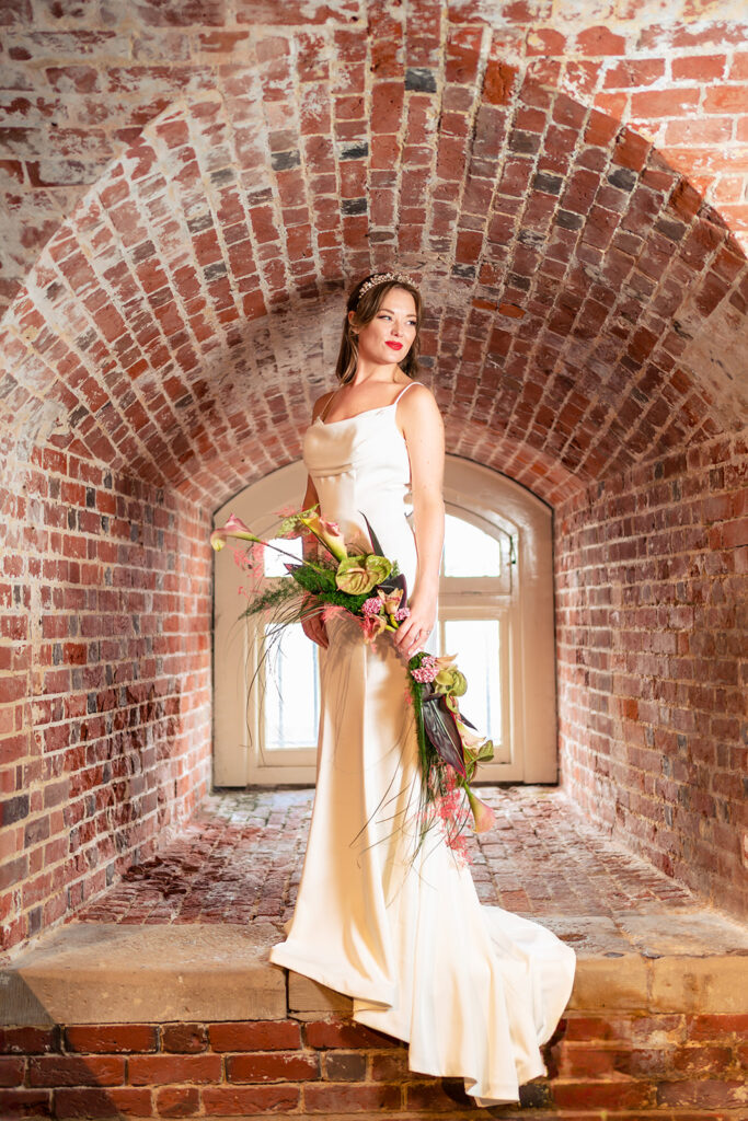 Bride in a brick arched window at Southsea Castle, Portsmouth (styled shoot)