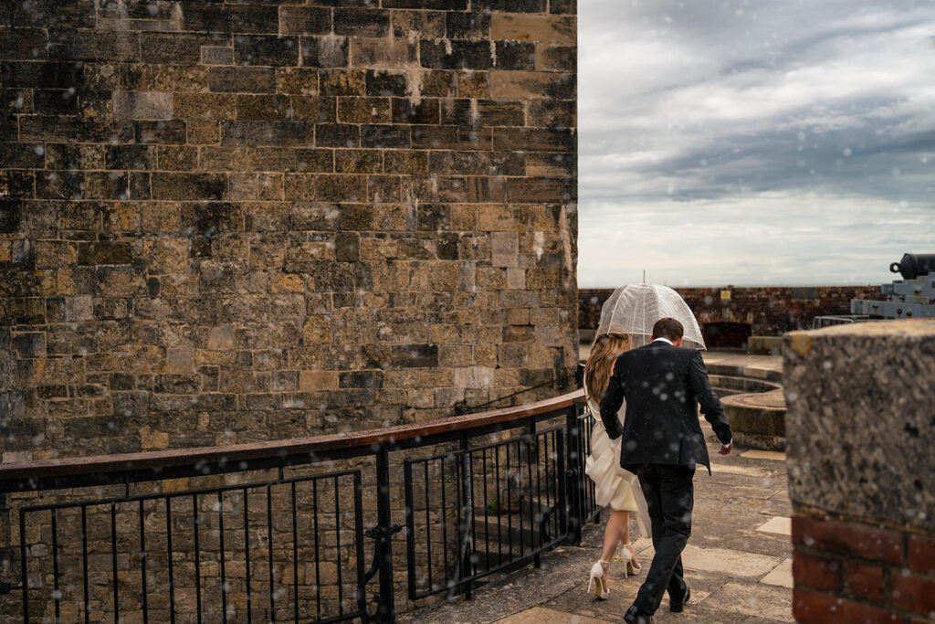 Couple by the castle walls with the sea behind at Southsea Castle, Portsmouth (styled shoot)