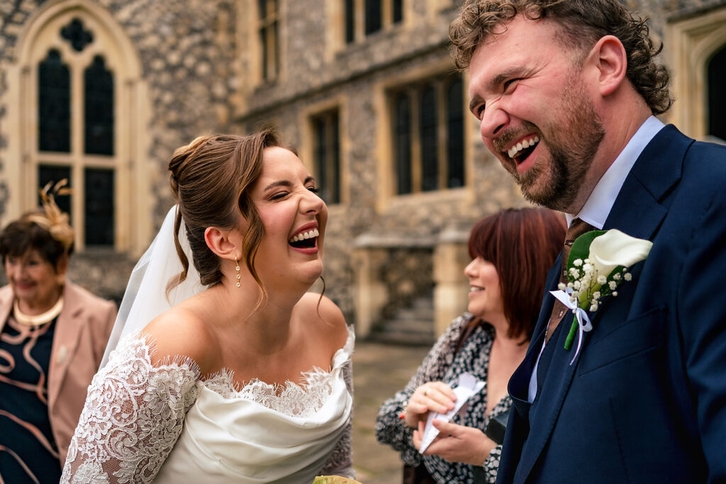 Bride laughing with the groom at Winchester Register Office, Hampshire