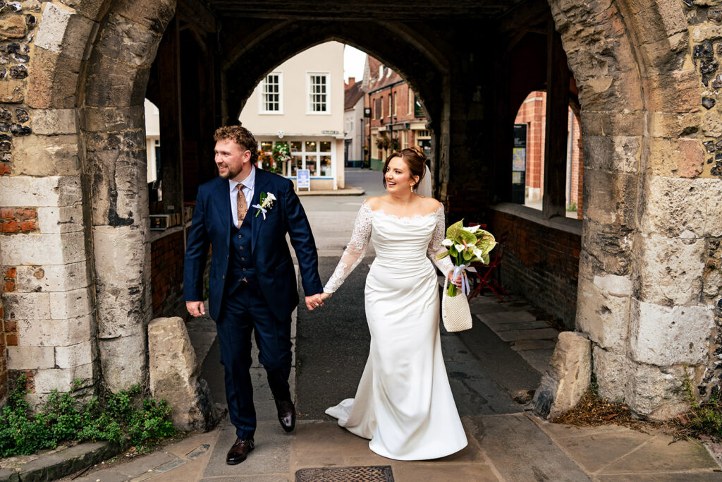 Bride and groom under a stone archway in Winchester
