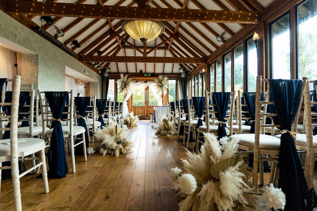 Ceremony room dressed in cream and navy with pampas grass at Old Thorns Hotel and Resort, Liphook