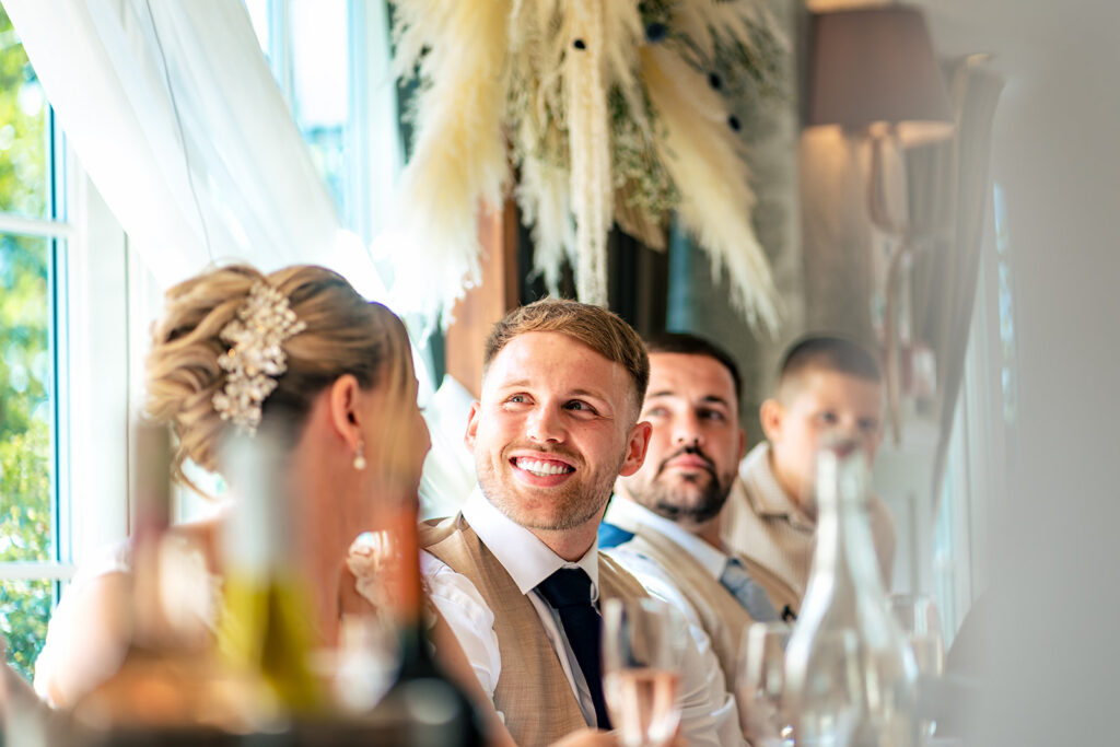Bride and groom with guests laughing at Old Thorns Hotel and Resort, Liphook