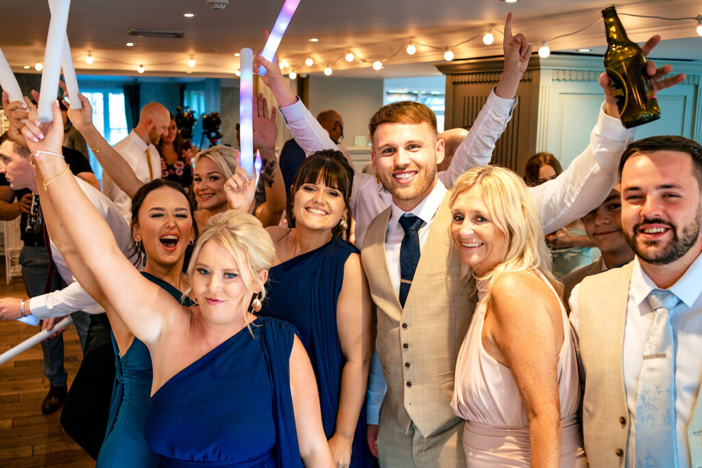Guests cheering with drinks at Old Thorns Hotel and Resort, Liphook
