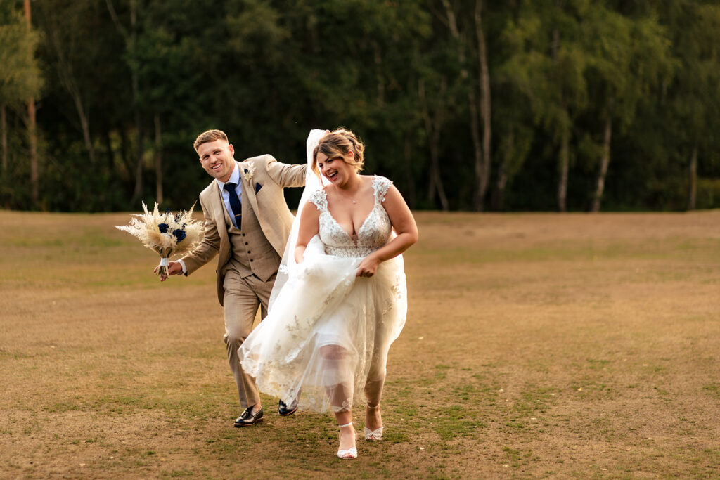 Bride laughing as she walks across the grass at Old Thorns Hotel and Resort, Liphook
