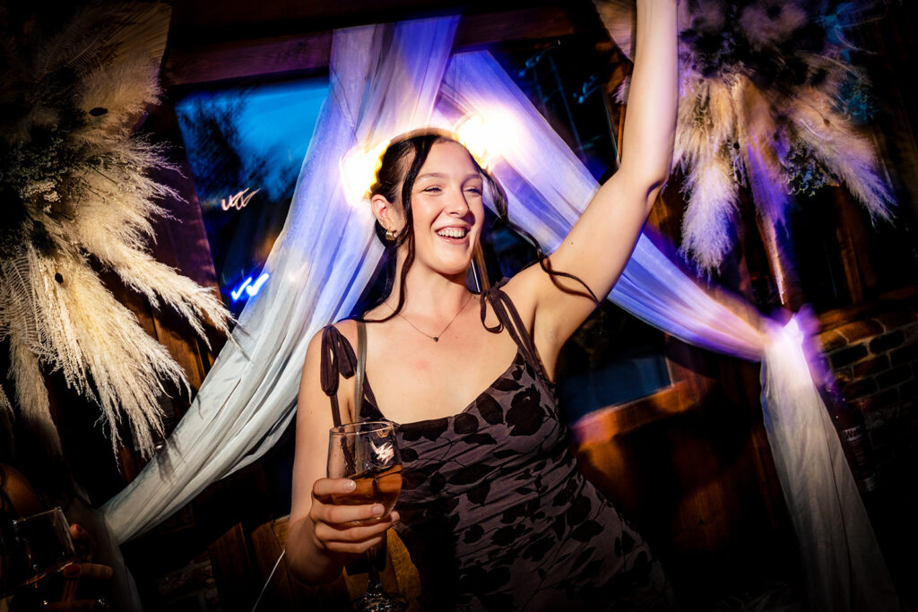 Guest dancing with colourful lights at Old Thorns Hotel and Resort, Liphook