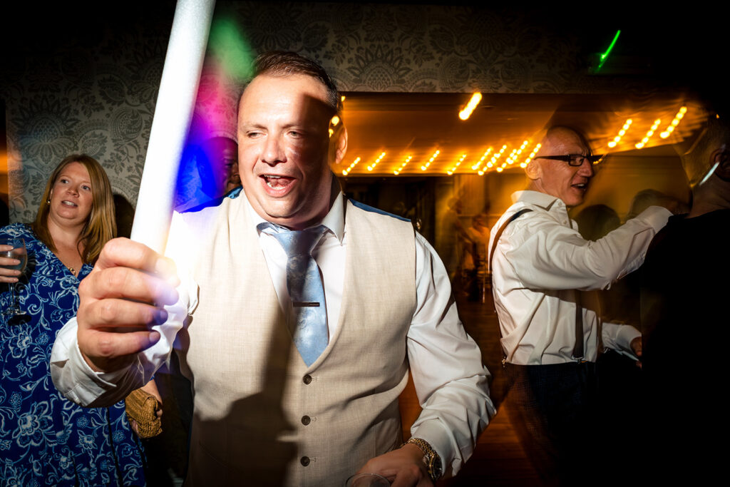 Guest raising a glass on the dancefloor at Old Thorns Hotel and Resort, Liphook