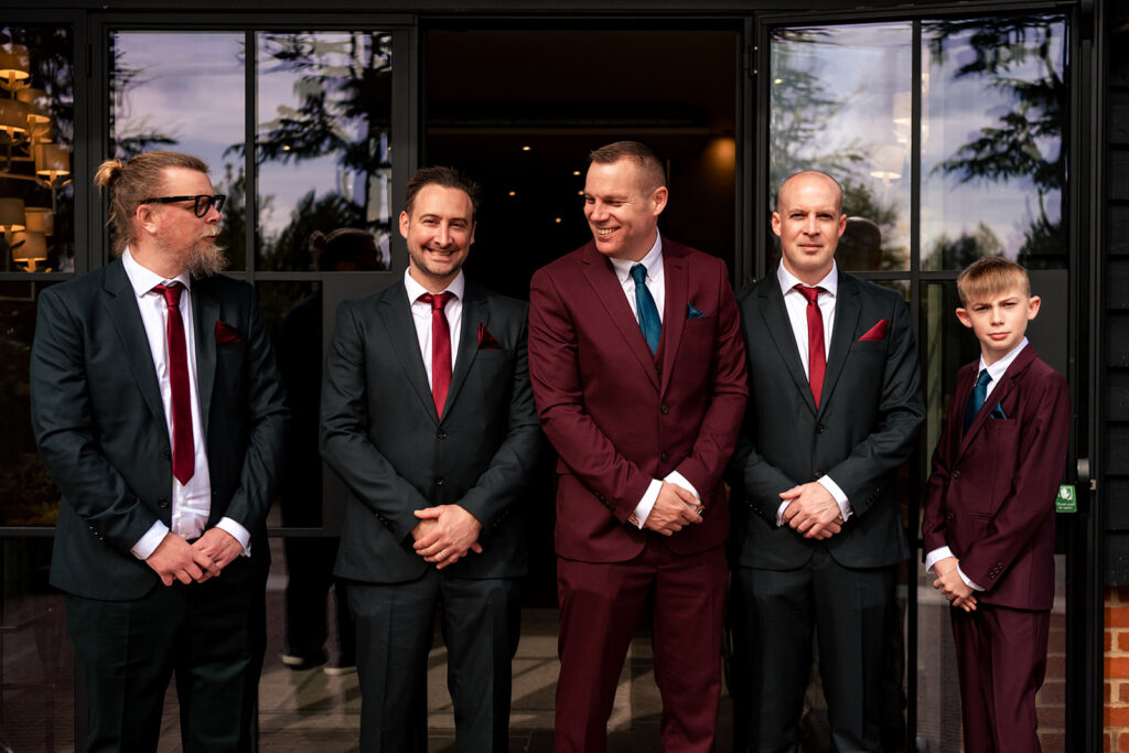 Groom and groomsmen in burgundy and black at The Post Barn, Newbury