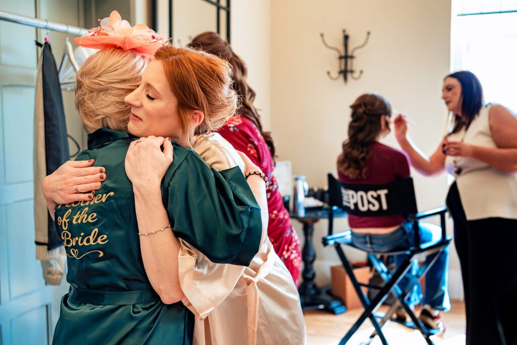 Bridesmaids hugging during getting ready at The Post Barn, Newbury