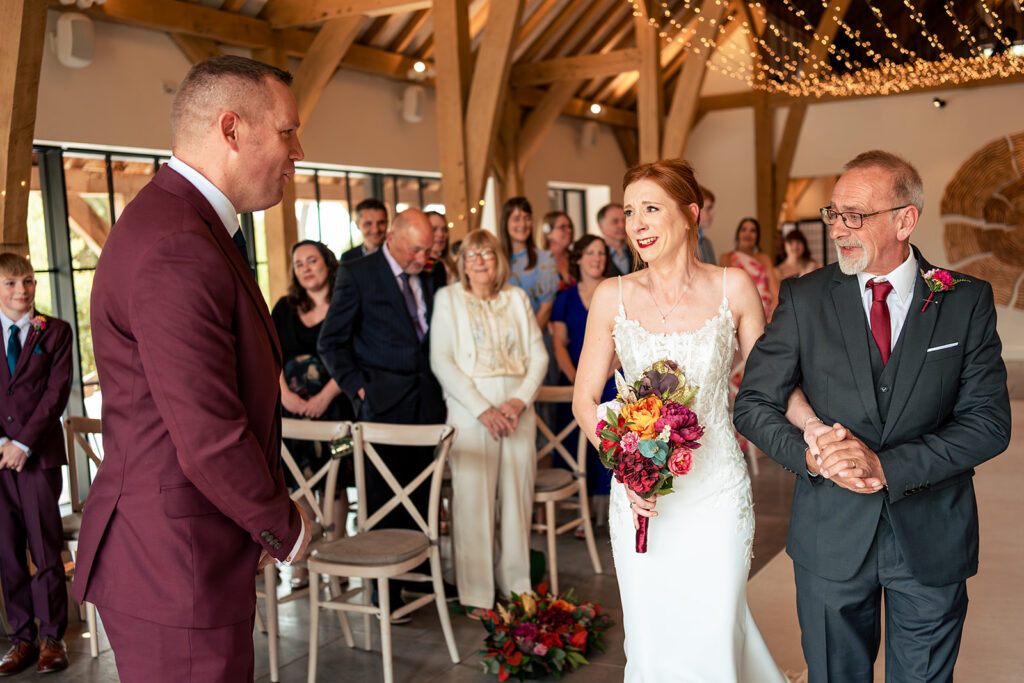 Bride walking down the aisle at The Post Barn, Newbury