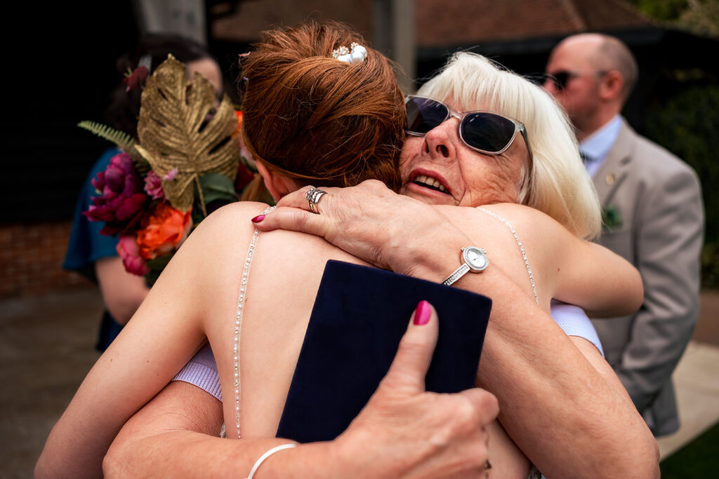 Bride in a big group hug at The Post Barn, Newbury