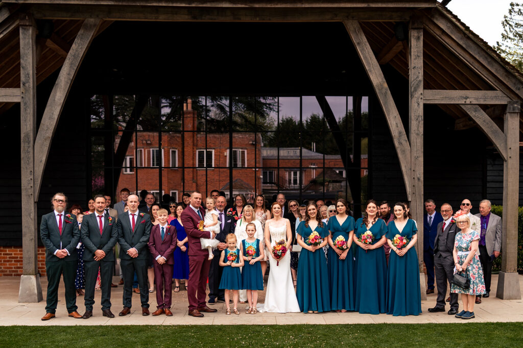 Bridal party lined up outside the barn at The Post Barn, Newbury
