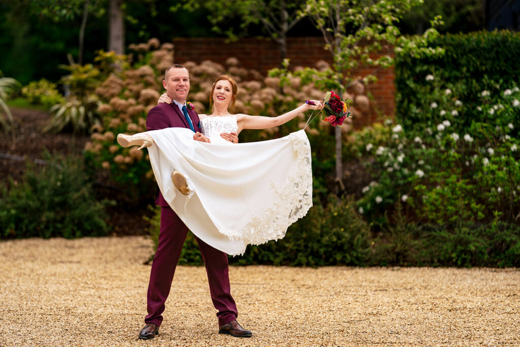 Groom lifting the bride in the gardens at The Post Barn, Newbury