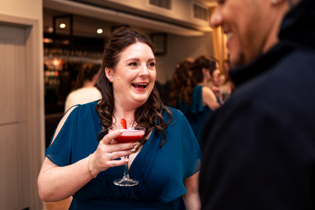 Guest laughing with a glass of wine at The Post Barn, Newbury