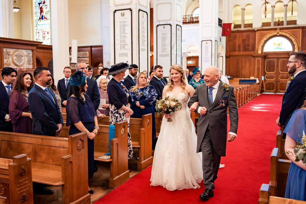 Bride walking down the aisle in the chapel at Royal Military Academy Sandhurst