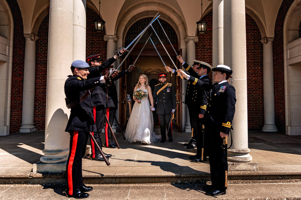 Newlyweds under a military sword arch at Royal Military Academy Sandhurst