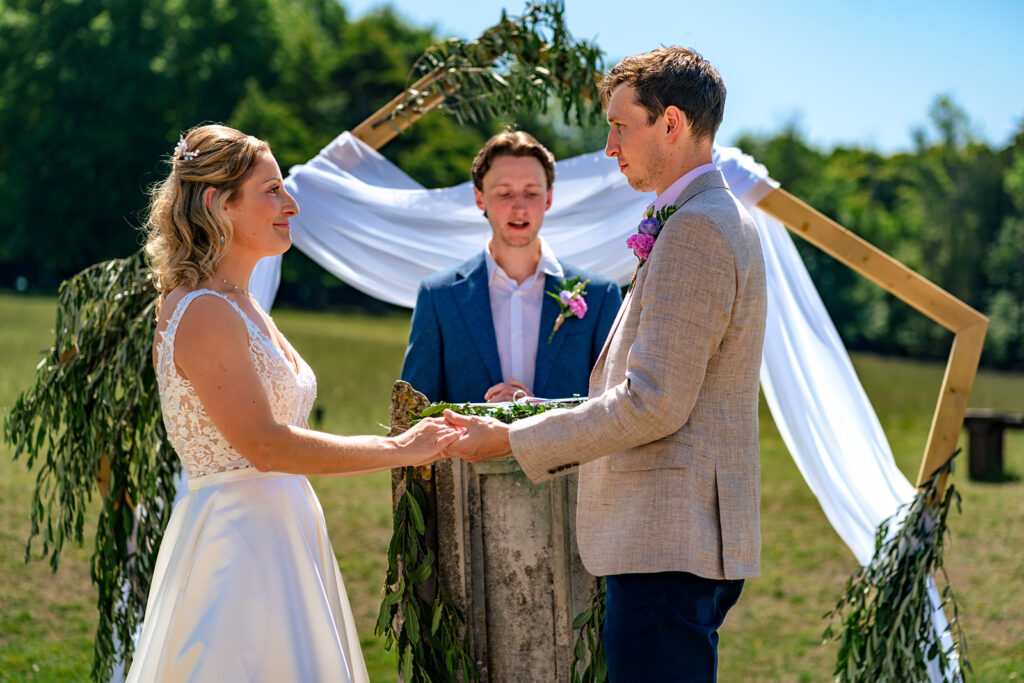 Vows under the floral arch at Great Ballard School, Eartham