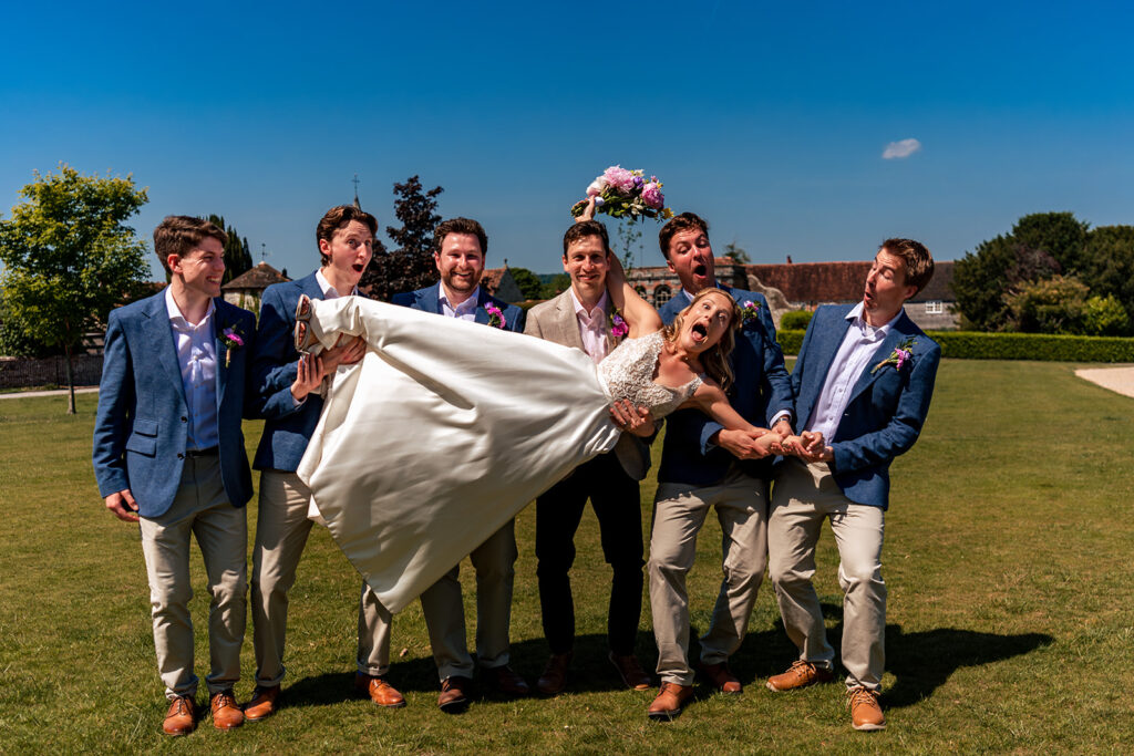 Groomsmen messing about on the lawn at Great Ballard School, Eartham