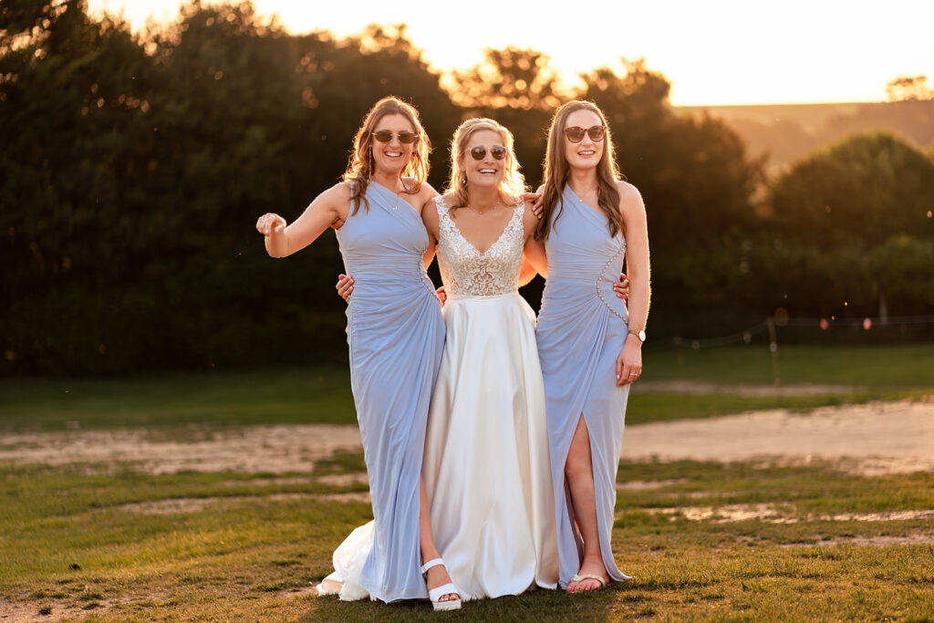 Bridesmaids laughing at golden hour at Great Ballard School, Eartham