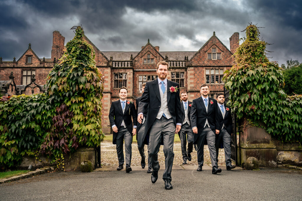 Groom and groomsmen in morning suits outside the hall at Dorfold Hall, Cheshire