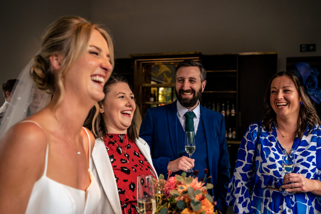 Bride laughing with guests at Dorfold Hall, Cheshire