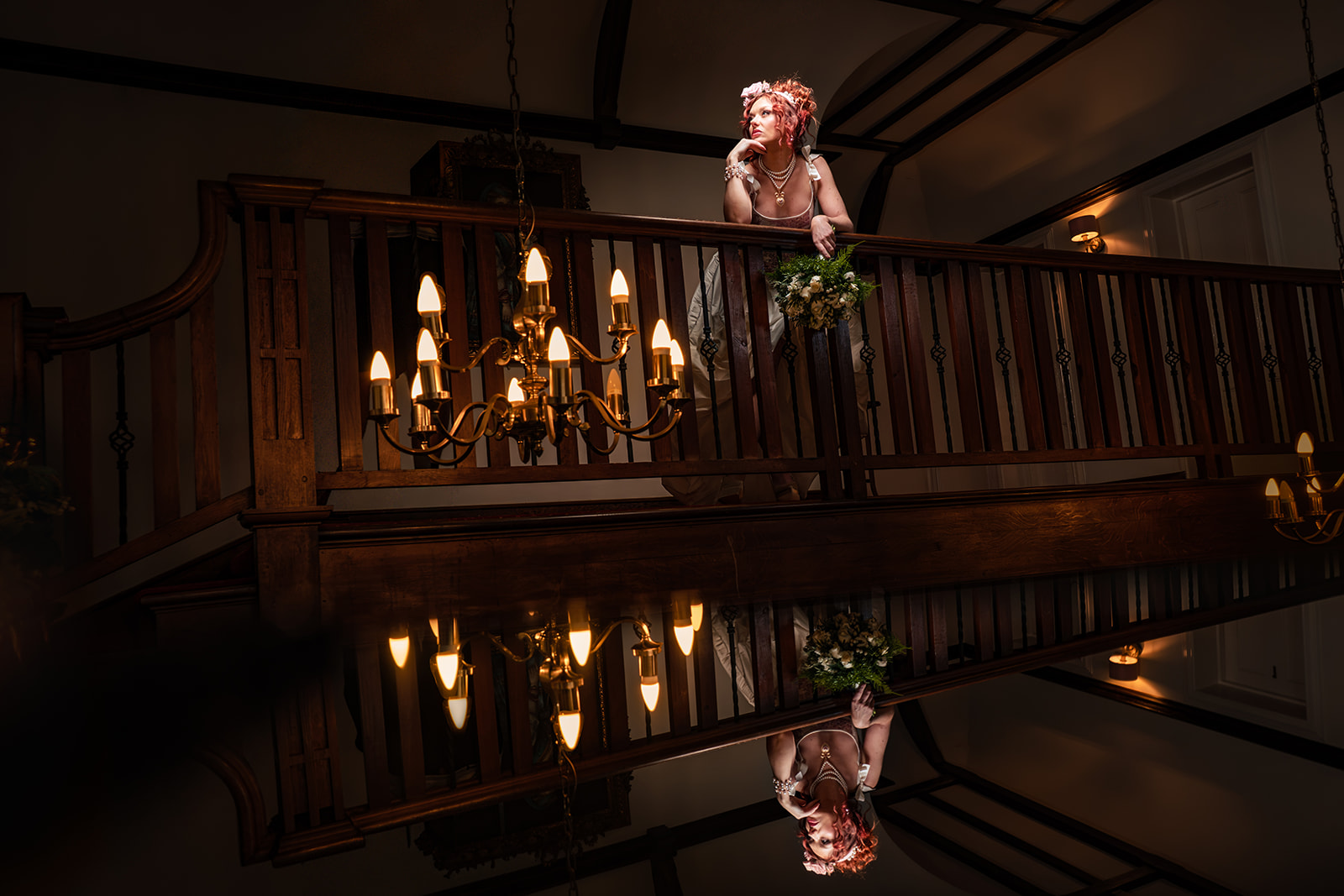 Flash lit bridal portrait on the landing at The Alverbank with a chandelier and mirror reflection