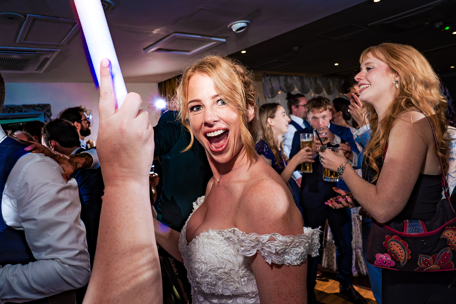 Bride singing with glow sticks on the dancefloor at Hotel Miramar Bournemouth