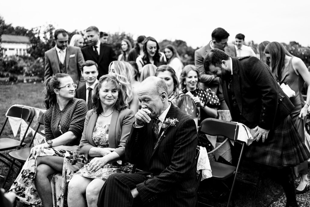Bridal party laughing, black and white at Houghton Lodge Gardens, Hampshire