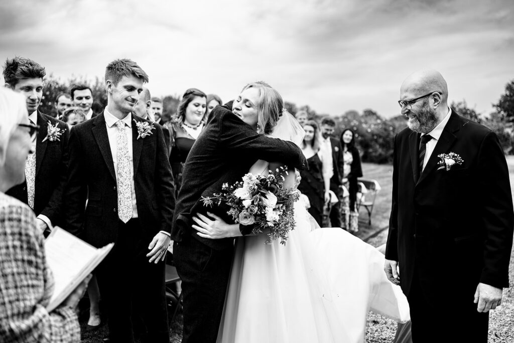 Laughter during the outdoor ceremony, black and white at Houghton Lodge Gardens, Hampshire