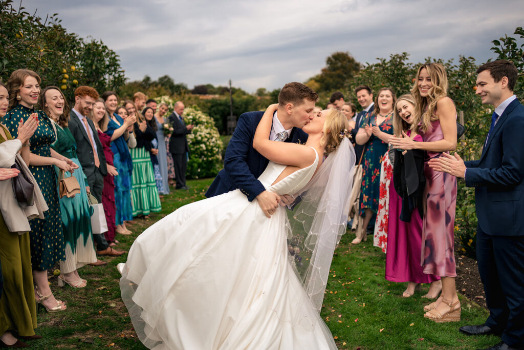 Bride hugging guests after the ceremony at Houghton Lodge Gardens, Hampshire