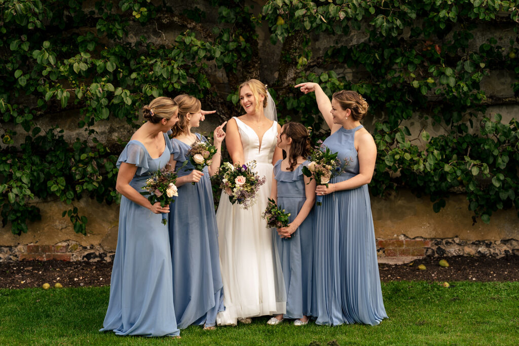 Bride with her bridesmaids in dusky blue at Houghton Lodge Gardens, Hampshire