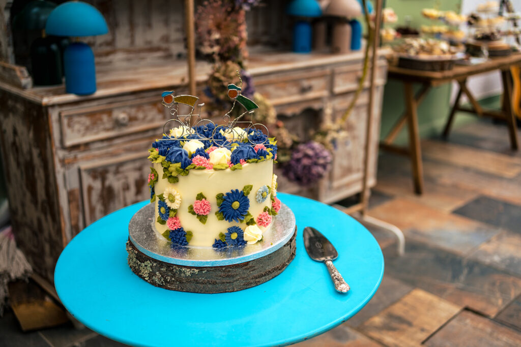 Wedding cake on a blue stand at Houghton Lodge Gardens, Hampshire