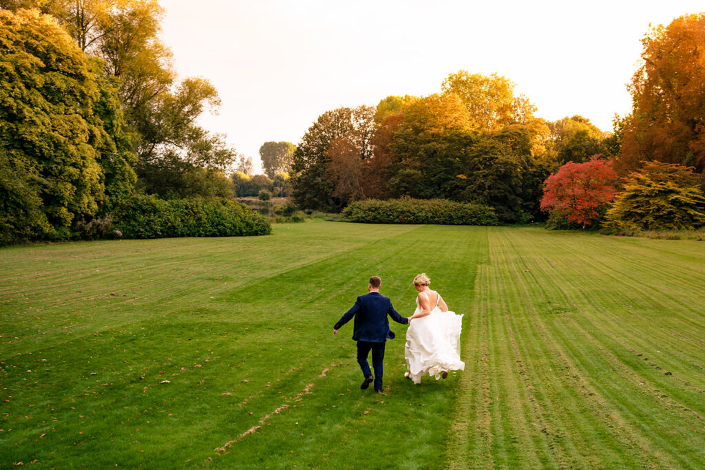 Walking hand in hand across the lawn at Houghton Lodge Gardens, Hampshire