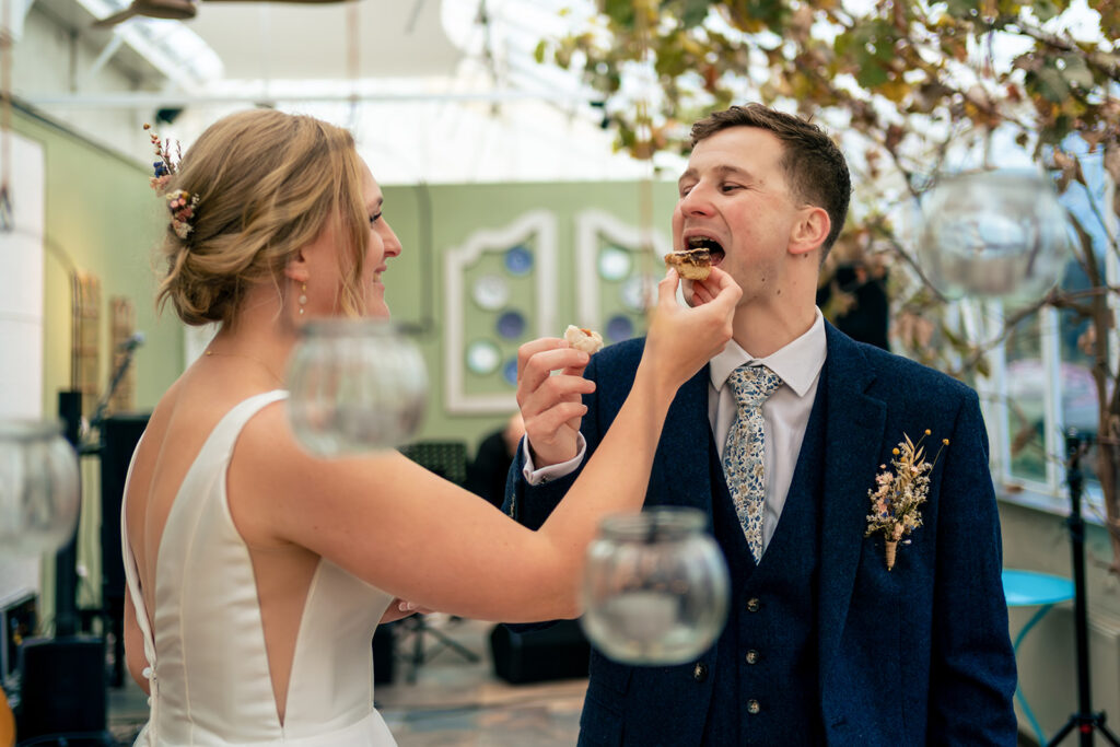 Groom laughing at the bar at Houghton Lodge Gardens, Hampshire