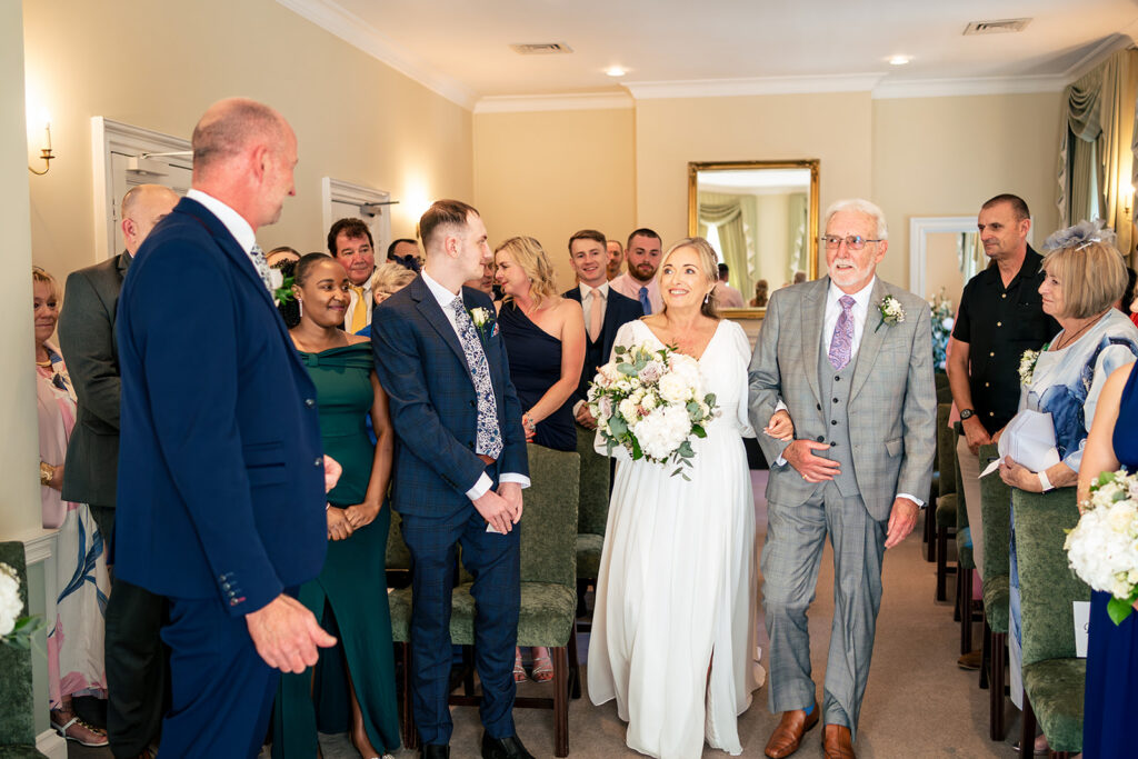 Groom waiting as the bride walks in