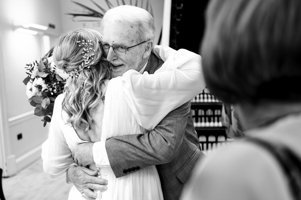 Bride hugging a guest, black and white