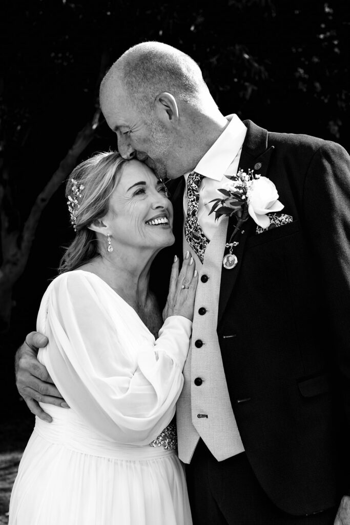 Bride and groom cuddle, black and white