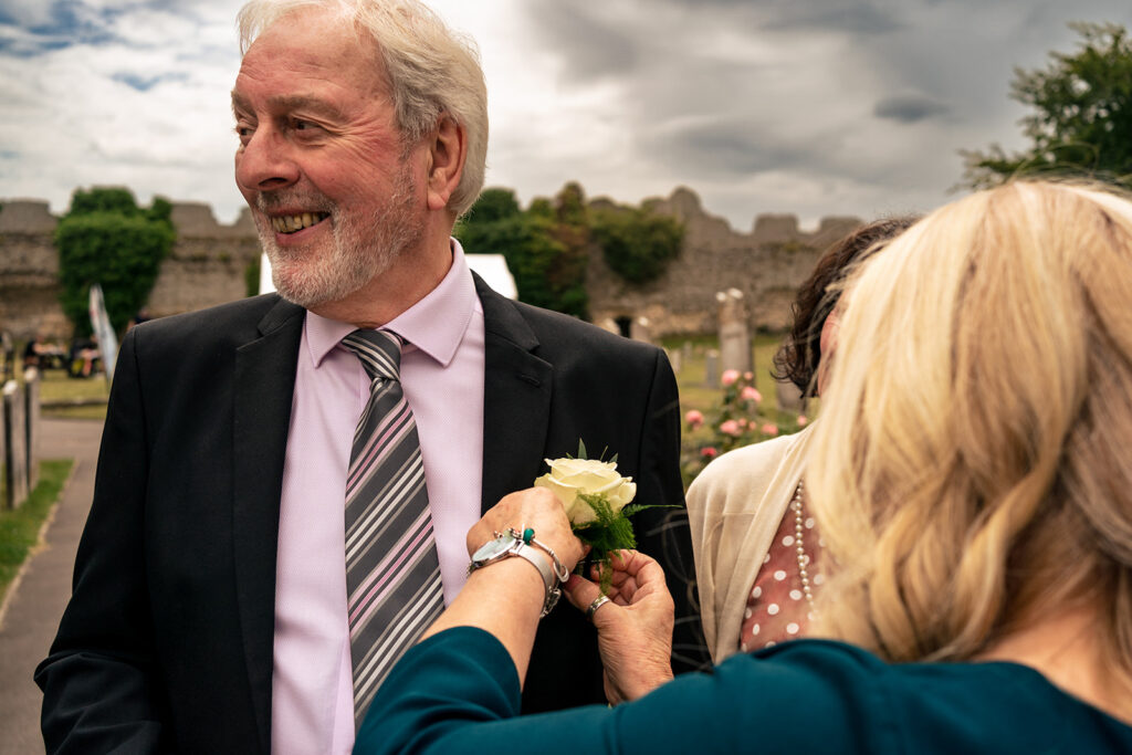 A guest adjusting a buttonhole at St Mary’s Church, Portchester