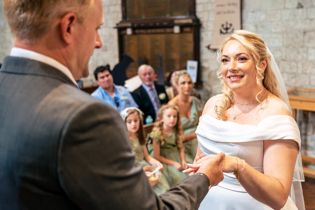 Bride greeting guests at the church door at St Mary’s Church, Portchester