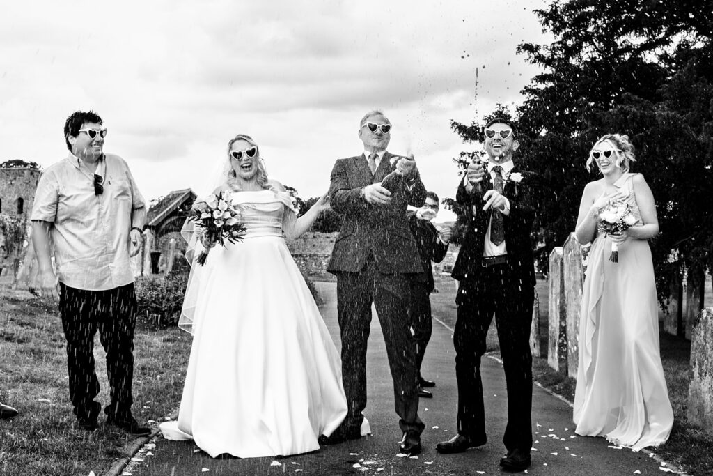 Bride and groom with guests, black and white at St Mary’s Church, Portchester