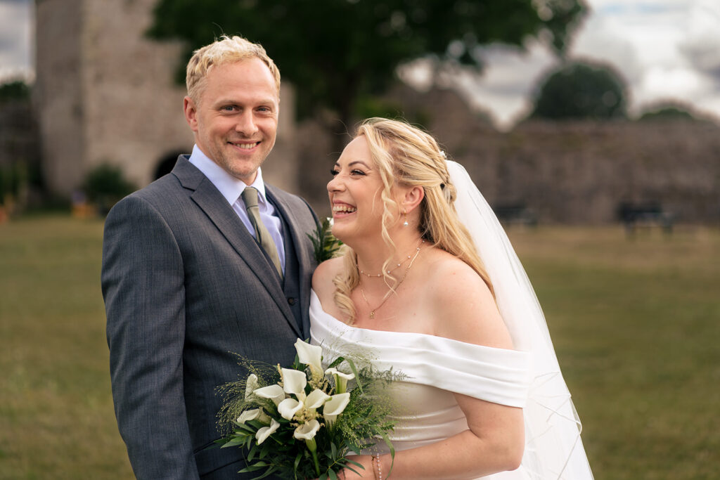Newlyweds sharing a laugh at St Mary’s Church, Portchester