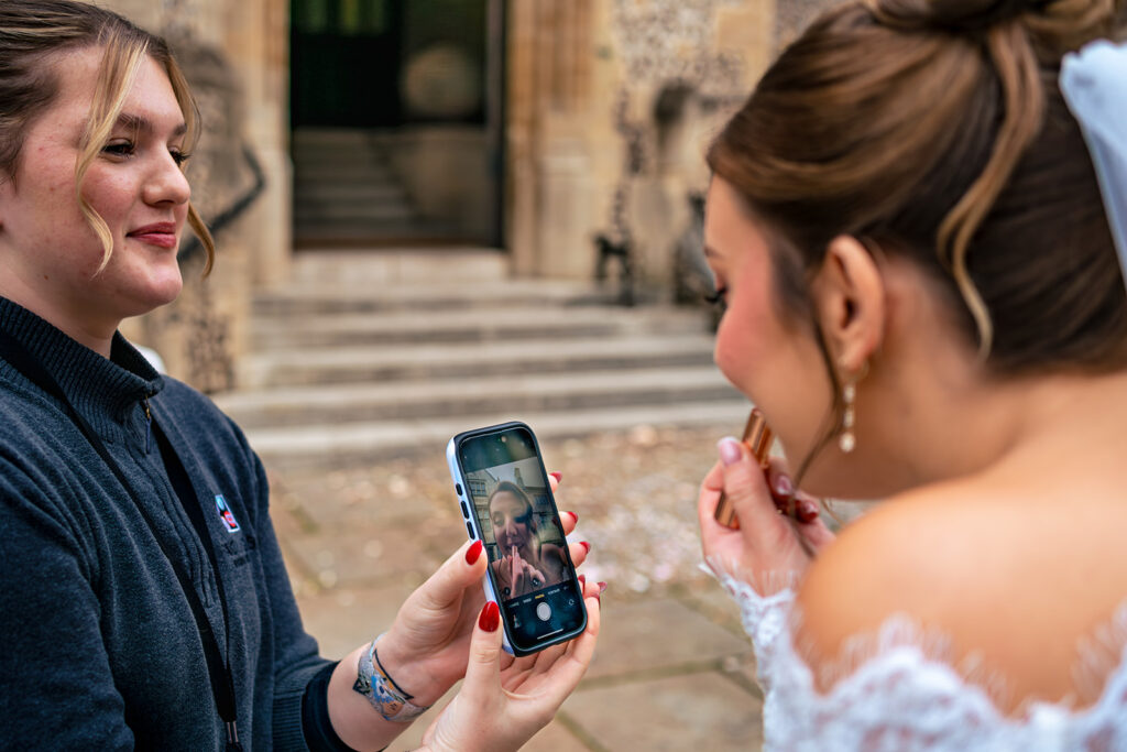 Guest showing the bride a photo on her phone at Winchester Register Office