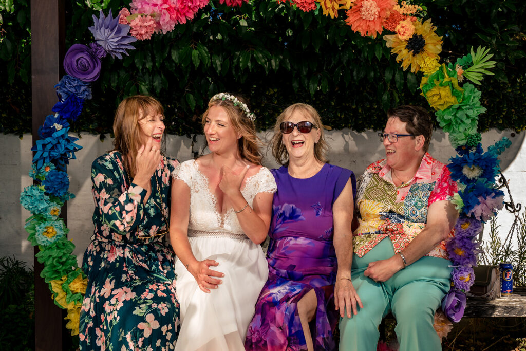 Brides with friends under the rainbow arch