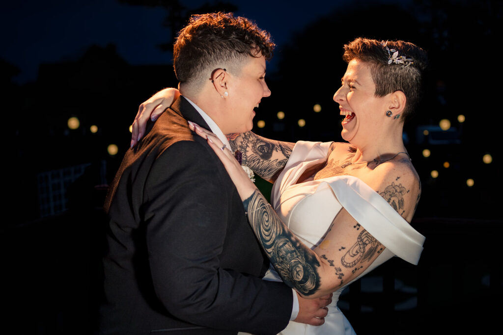 Two brides laughing at night with flash