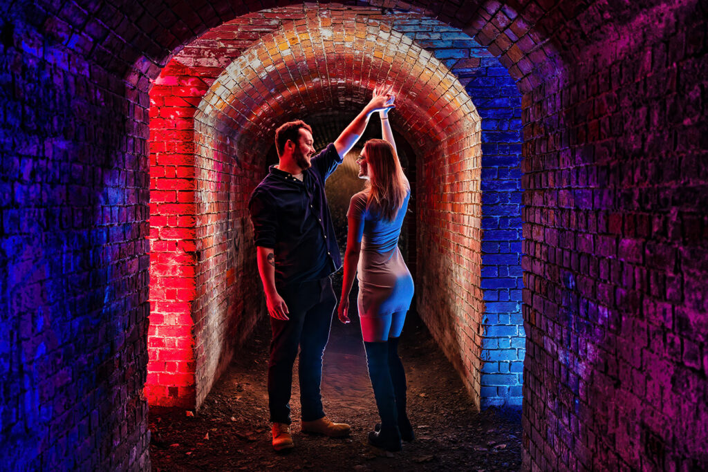 Couple in a tunnel lit with red and blue gels