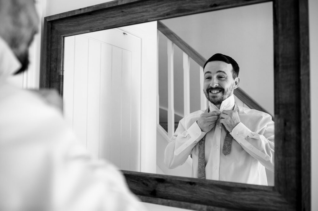 Groom reflected in the mirror, black and white at Newtown House Hotel, Hayling Island