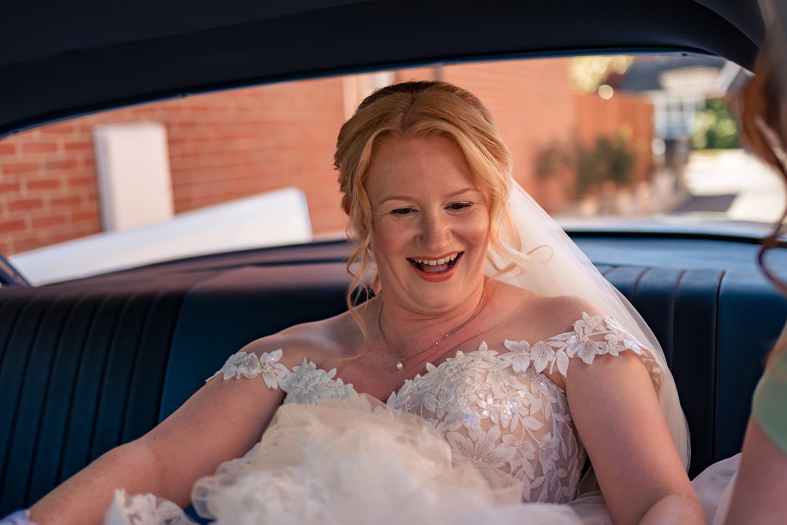 Bride laughing in the vintage wedding car on the way to The Square Tower, Old Portsmouth